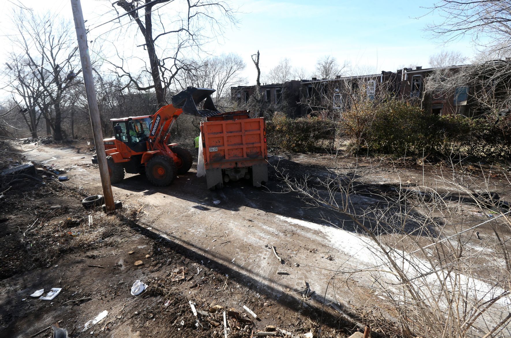 Broderick Young uses a front end loader to clean up an alley